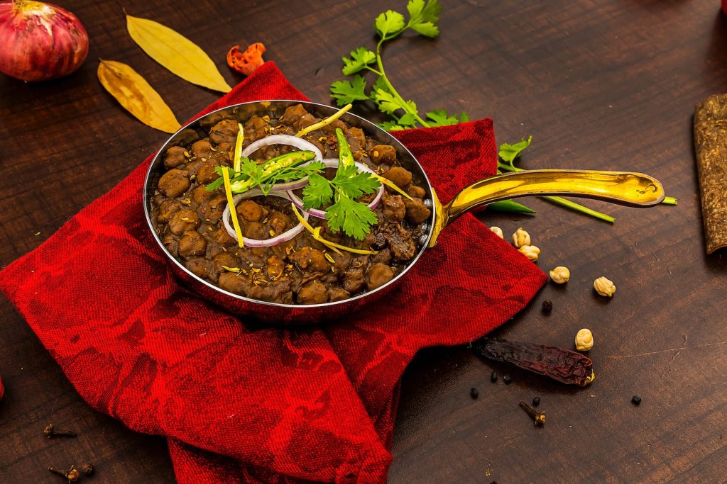 a bowl of food sitting on top of a red cloth Photo by Anil Sharma